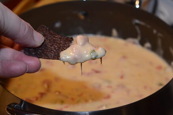 queso in fondue pot on blue corn chip