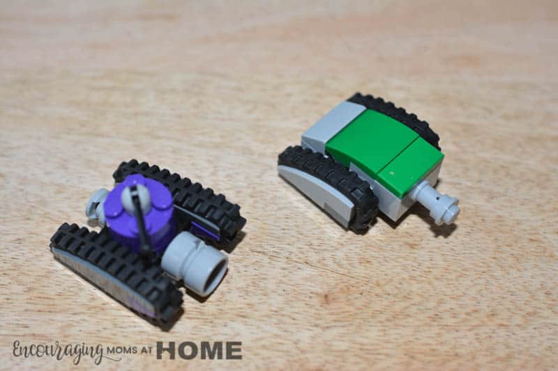 Two Lego Mini tanks face an unseen enemy. One is purple. The other is green.